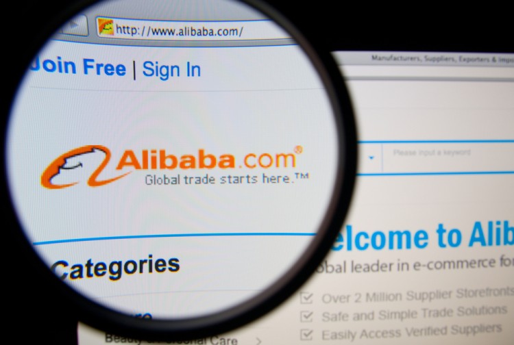 Alibaba Group Holding Ltd (NYSE:BABA), homepage on a monitor screen through a magnifying glass, retail, group, page